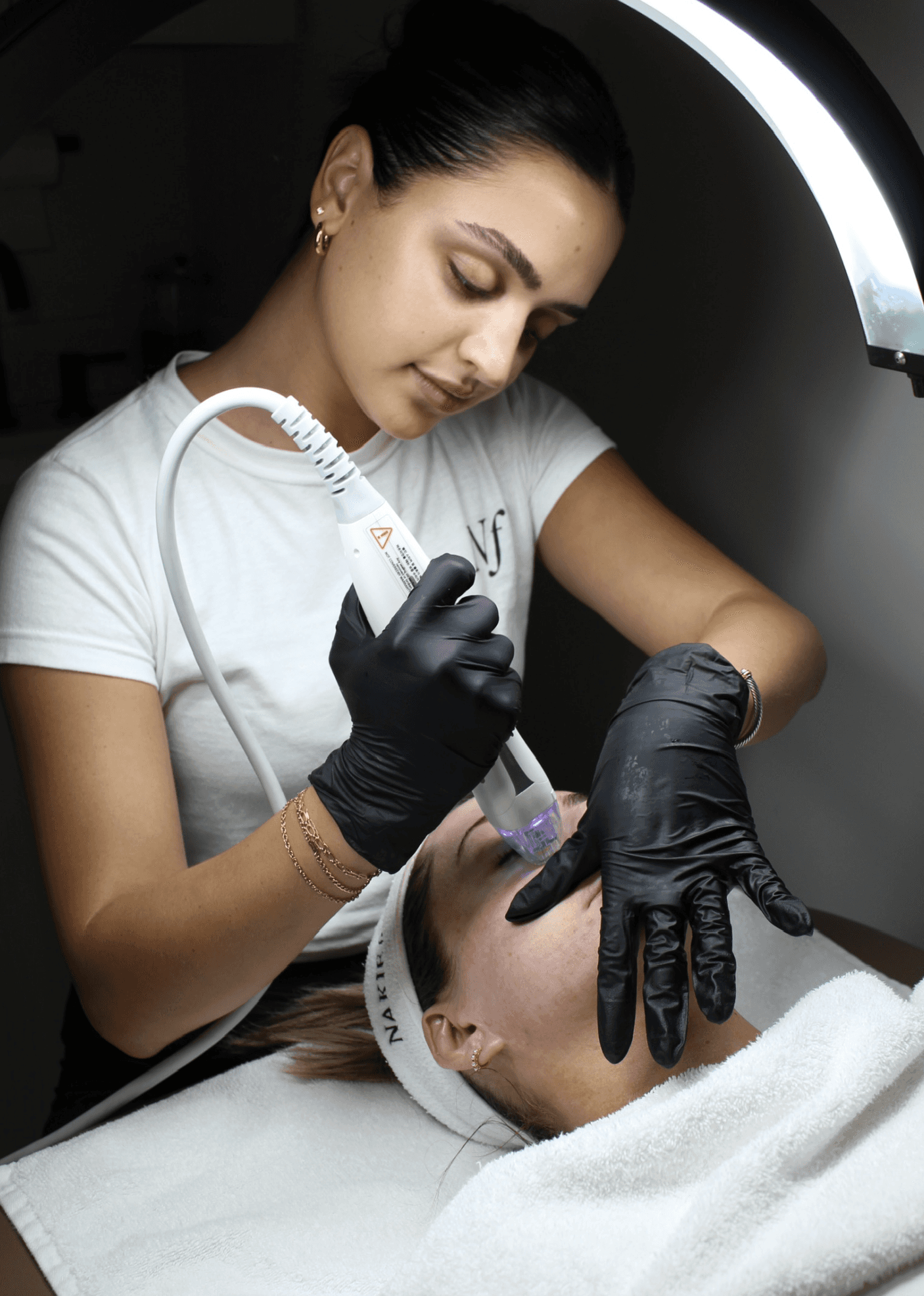 Nakie Face aesthetician performing a facial treatment